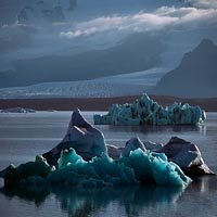 Plovoucí kry v jezeru Jokulsárlón - v pozadí ledovec Fjallsjokull, Island